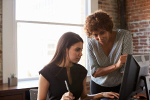 Two Multigenerational Businesswomen Working On Computer In Office.